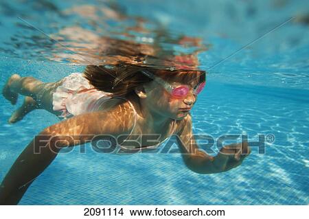Picture - A girl swimming under the water in a pool with goggles on; tarifa, cadiz, andalusia, spain. Fotosearch