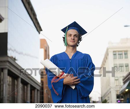 A graduate in cap and gown holding his degree on an urban street; victoria, british columbia, canada View Large Photo Image Stock Photo - A graduate in cap and gown holding his degree on an urban street; victoria, british columbia, canada. Fotosearch