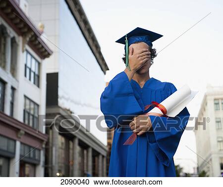 A graduate in cap and gown holds his hand over his eyes; victoria, british columbia, canada View Large Photo Image Stock Image - A graduate in cap and gown holds his hand over his eyes; victoria, british columbia, canada. Fotosearch