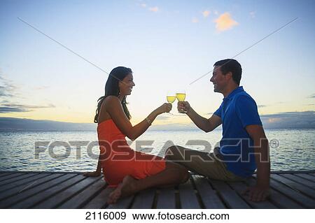 A man and woman toasting with drinks at the water's edge at the bora bora nui resort and spa; bora bora island society islands french polynesia south pacific View Large Photo Image Stock Photo - A man and woman toasting with drinks at the water's edge at the bora bora nui resort and spa; bora bora island society islands french polynesia south pacific. Fotosearch