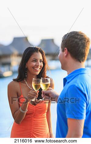 A man and woman toasting with drinks at the water's edge at the bora bora nui resort and spa; bora bora island society islands french polynesia south pacific View Large Photo Image Stock Photograph - A man and woman toasting with drinks at the water's edge at the bora bora nui resort and spa; bora bora island society islands french polynesia south pacific. Fotosearch