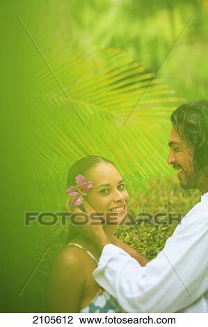 A man puts a flower in a woman's hair at the bora bora nui resort and spa; bora bora island society islands french polynesia south pacific View Large Photo Image Stock Image - A man puts a flower in a woman's hair at the bora bora nui resort and spa; bora bora island society islands french polynesia south pacific. Fotosearch