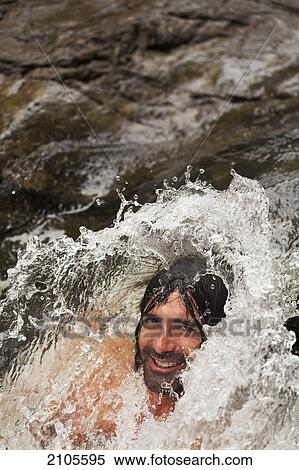 Stock Photography - A man with water splashing over his head; gold coast queensland australia. Fotosearch
