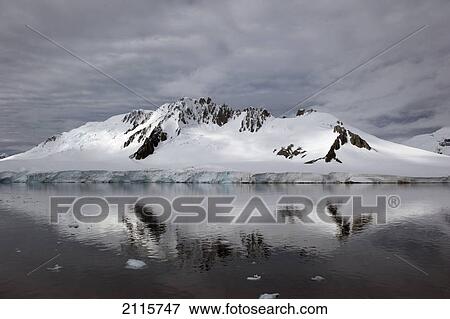 Stock Photo - A mountain reflected in the tranquil southern ocean; antarctica. Fotosearch