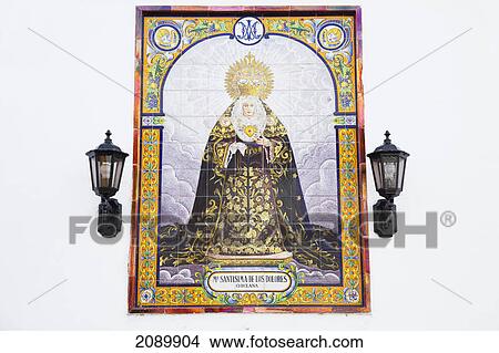 A religious figure on tile on a white wall with mounted lights; chiclana de la frontera, andalusia, spain View Large Photo Image Picture - A religious figure on tile on a white wall with mounted lights; chiclana de la frontera, andalusia, spain. Fotosearch