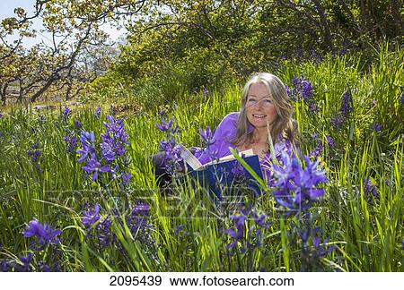 A senior woman reads in a sea of camassia; victoria british columbia canada View Large Photo Image Stock Photo - A senior woman reads in a sea of camassia; victoria british columbia canada. Fotosearch