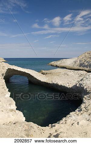 A tranquil pool of water and unique rock formation off the coast; karpos, island of milos, greece View Large Photo Image Stock Photo - A tranquil pool of water and unique rock formation off the coast; karpos, island of milos, greece. Fotosearch