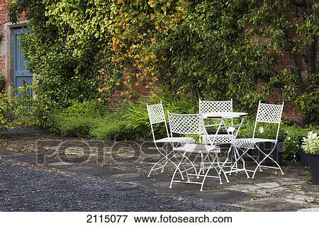 Stock Photo - A white table and four chairs on a patio; scottish borders scotland. Fotosearch