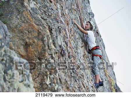Stock Photo - A woman climbs a rock face; tarifa cadiz andalusia spain. Fotosearch