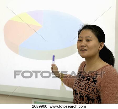 Stock Image - A woman doing a presentation with a pie chart; beijing, china. Fotosearch