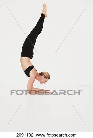 Stock Image - A woman in a yoga pose; tarifa, cadiz, andalusia, spain. Fotosearch
