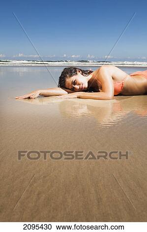 A woman lays in the shallow water over the sand; gold coast queensland australia View Large Photo Image Stock Image - A woman lays in the shallow water over the sand; gold coast queensland australia. Fotosearch
