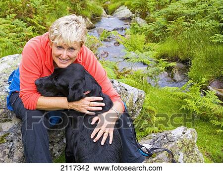 Stock Image - A woman with her dog; ullswater cumbria england. Fotosearch