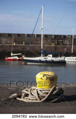A yellow post with a rope on the shore of the harbour; dunbar, scottish borders, scotland View Large Photo Image Stock Image - A yellow post with a rope on the shore of the harbour; dunbar, scottish borders, scotland. Fotosearch