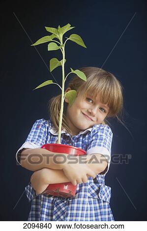 A young girl holding a potted plant; gold coast queensland australia View Large Photo Image Stock Image - A young girl holding a potted plant; gold coast queensland australia. Fotosearch