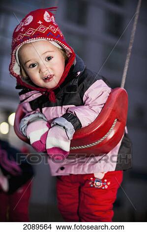 A young girl leaning on a swing at the playground; beijing, china View Large Photo Image Picture - A young girl leaning on a swing at the playground; beijing, china. Fotosearch