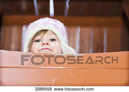 A young girl peeks over edge of playground equipment; beijing, china View Large Photo Image Stock Photo - A young girl peeks over edge of playground equipment; beijing, china. Fotosearch