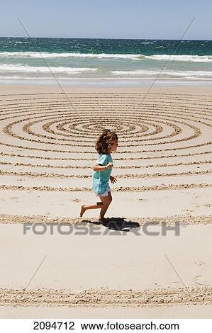 A young girl running along a swirl pattern in the sand of the beach at byron bay; new south wales, australia View Large Photo Image Stock Image - A young girl running along a swirl pattern in the sand of the beach at byron bay; new south wales, australia. Fotosearch