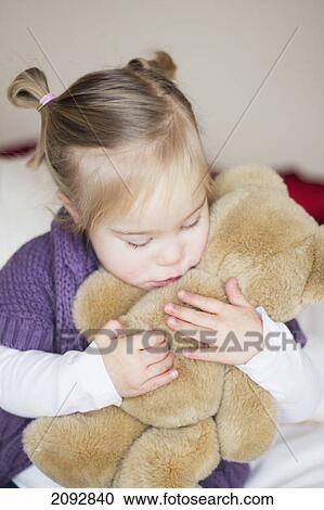A young girl with down syndrome cuddles with her teddy bear; cambridge, england View Large Photo Image Stock Image - A young girl with down syndrome cuddles with her teddy bear; cambridge, england. Fotosearch