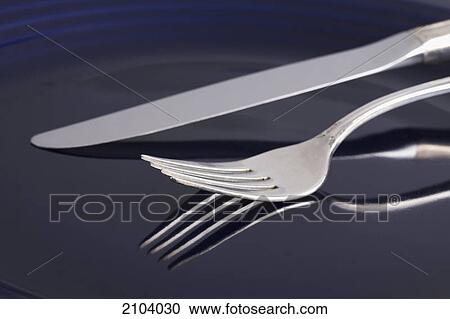 Close up of a fork and knife on a blue plate with reflection; calgary alberta canada View Large Photo Image Stock Image - Close up of a fork and knife on a blue plate with reflection; calgary alberta canada. Fotosearch