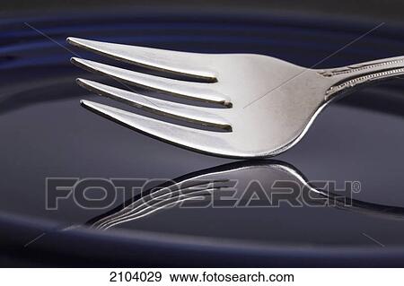 Close up of a fork on a blue plate with reflection; calgary alberta canada View Large Photo Image Stock Photo - Close up of a fork on a blue plate with reflection; calgary alberta canada. Fotosearch