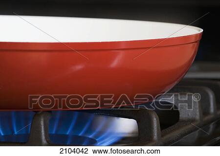 Close up of a red frying pan on a gas stove with blue gas burner; calgary alberta canada View Large Photo Image Stock Image - Close up of a red frying pan on a gas stove with blue gas burner; calgary alberta canada. Fotosearch