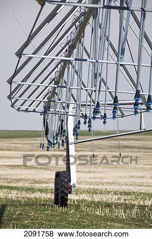 Stock Photo - Close up of an irrigation system in field with blue sky; alberta, canada. Fotosearch
