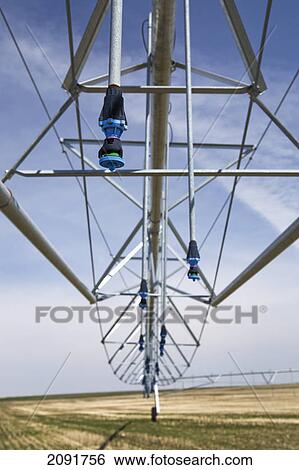Stock Photograph - Close up of an irrigation system in field with blue sky and clouds; alberta, canada. Fotosearch