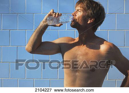Fit man drinking water in changing room after exercising; torremolinos malaga province spain View Large Photo Image Stock Photo - Fit man drinking water in changing room after exercising; torremolinos malaga province spain. Fotosearch