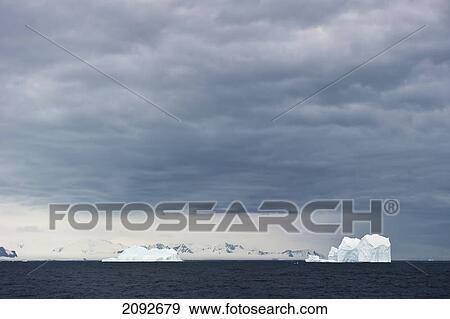 Stock Photo - Icebergs under a cloudy sky; antarctica. Fotosearch