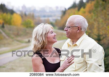Picture - Mature married couple enjoying spending time together in park during fall season; edmonton, alberta, canada. Fotosearch