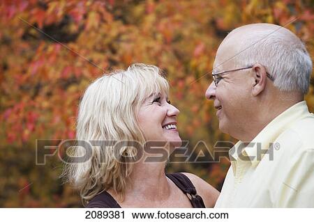 Stock Image - Mature married couple enjoying spending time together in park during fall season; edmonton, alberta, canada. Fotosearch