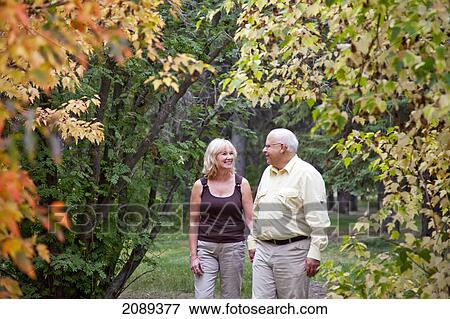 Mature married couple enjoying spending time together in park during fall season; edmonton, alberta, canada View Large Photo Image Stock Photo - Mature married couple enjoying spending time together in park during fall season; edmonton, alberta, canada. Fotosearch