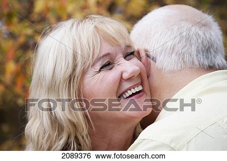 Stock Photograph - Mature married couple enjoying spending time together in park during fall season; edmonton, alberta, canada. Fotosearch