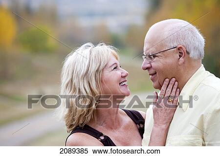 Stock Photography - Mature married couple enjoying spending time together in park during fall season; edmonton, alberta, canada. Fotosearch
