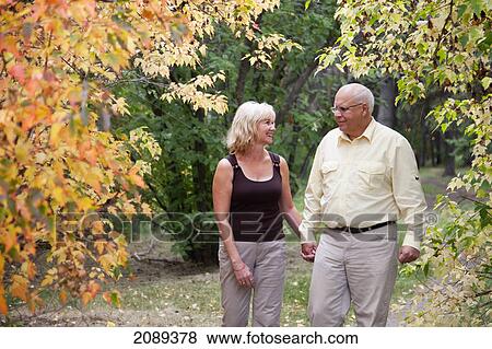 Mature married couple walking together in park during fall season; edmonton, alberta, canada View Large Photo Image Stock Photo - Mature married couple walking together in park during fall season; edmonton, alberta, canada. Fotosearch