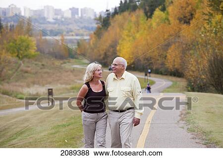 Mature married couple walking together in park during fall season; edmonton, alberta, canada View Large Photo Image Stock Photo - Mature married couple walking together in park during fall season; edmonton, alberta, canada. Fotosearch