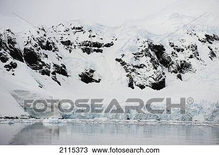 Stock Image - Mountains and glaciers reflected in the water; antarctica. Fotosearch