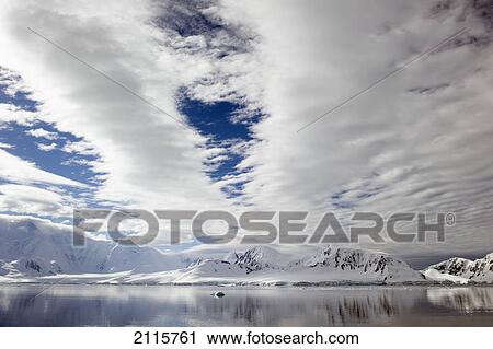 Stock Image - Mountains reflected in the water; antarctica. Fotosearch