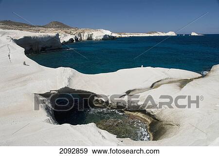 Stock Photo - Pool of water and unique rock formations along the coast; sarakiniko, island of milos, greece. Fotosearch