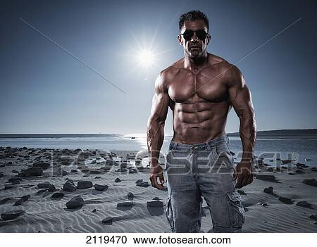 Portrait of a muscular man standing on a beach in sunglasses; tarifa cadiz andalusia spain View Large Photo Image Stock Image - Portrait of a muscular man standing on a beach in sunglasses; tarifa cadiz andalusia spain. Fotosearch