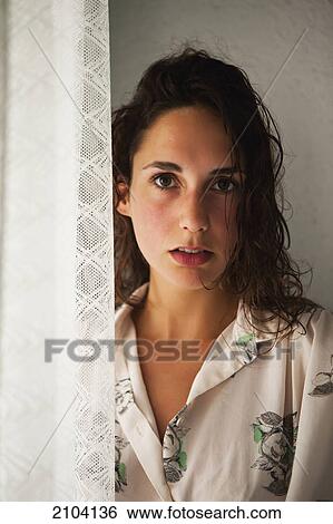 Stock Photograph - Portrait of a woman standing by a window; gold coast queensland australia. Fotosearch
