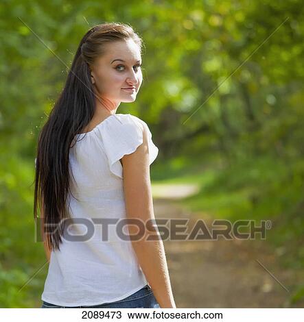Stock Image - Portrait of a young woman on a path in a park; edmonton, alberta, canada. Fotosearch