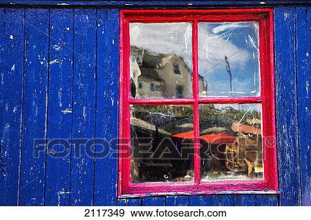 Stock Photo - Reflection in a red trimmed window on a blue building; st abb's head scottish borders scotland. Fotosearch