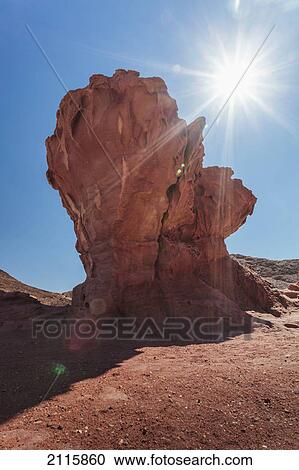 Stock Image - Rock formation with a sunburst; timna park arabah israel. Fotosearch