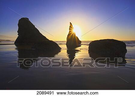 Stock Image - Rock formations at low tide on bandon beach at sunset; oregon, united states of america. Fotosearch