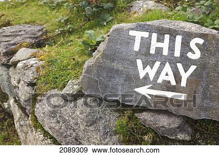 Stock Photo - Sign saying 'this way' leading visitors around at molly gallivan's cottage and traditional farm visitor centre; bonane, kenmare, county kerry, republic of ireland. Fotosearch