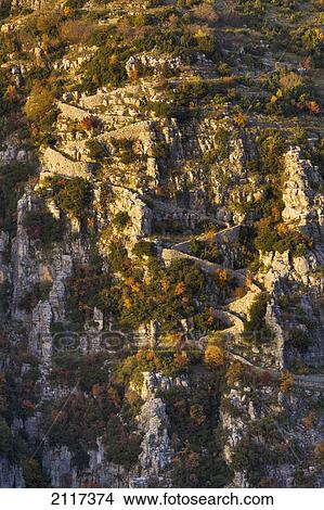 The last rays of autumn sun highlight the twists and turns of the vradeto steps in zagoria; epirus greece View Large Photo Image Picture - The last rays of autumn sun highlight the twists and turns of the vradeto steps in zagoria; epirus greece. Fotosearch