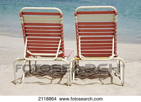 Picture - Two pink lounge chairs on a white sand beach; cane garden bay tortula british virgin island. Fotosearch