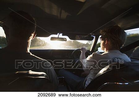 Stock Photo - Two young men in the front seat of a car; dunsborough, west australia, australia. Fotosearch